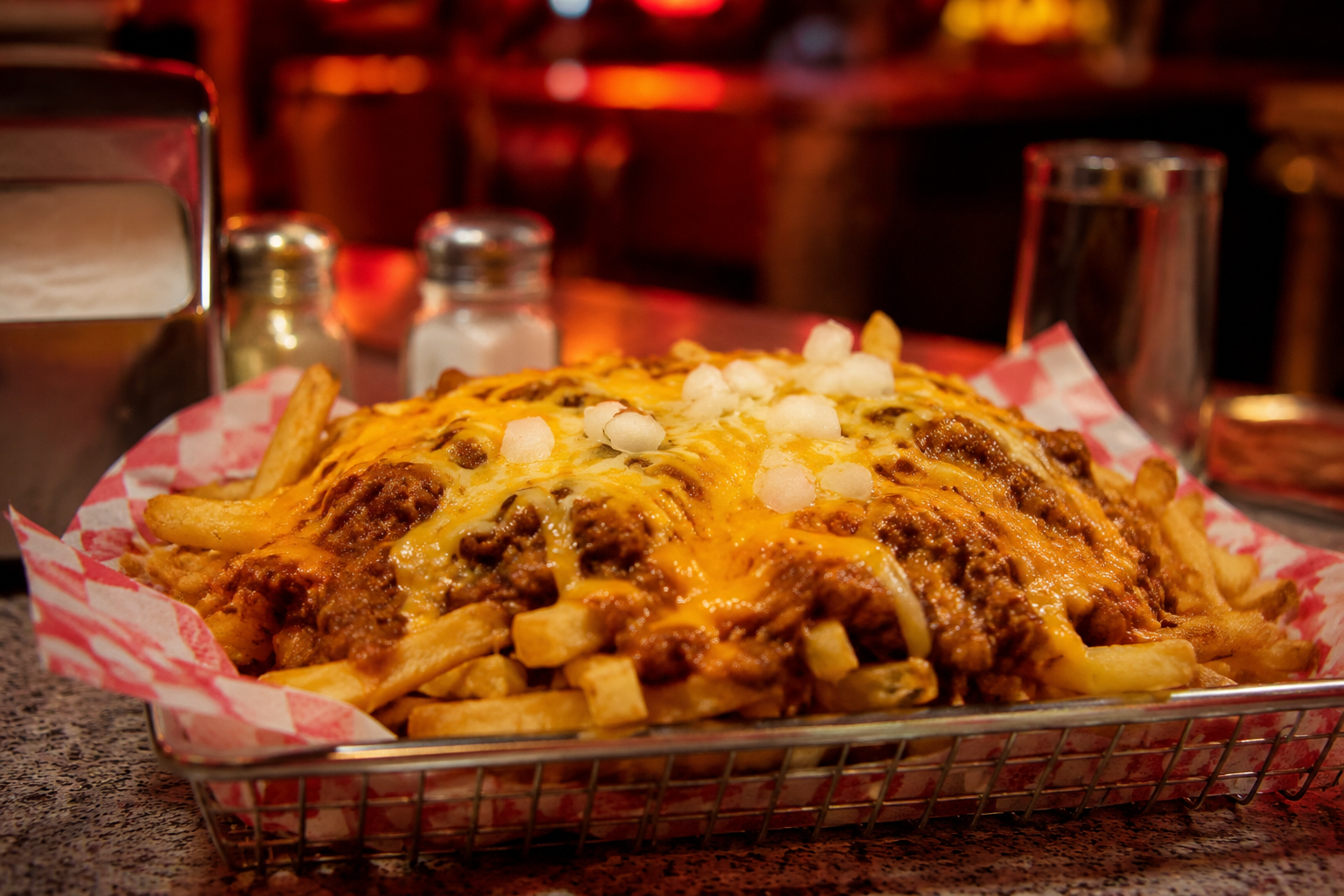 Chili cheese fries in a metal basket on a diner counter